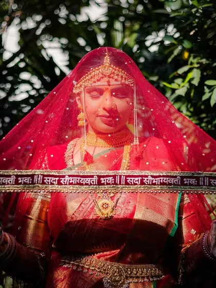 The bride, Urmi, holds her customized veil, which has a Sanskrit blessing embroidered on it. A beautiful, personal detail.