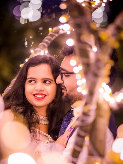 Another perspective of a candid moment, with the couple framed by glowing lights. I look for these unscripted interactions to tell a more authentic love story.