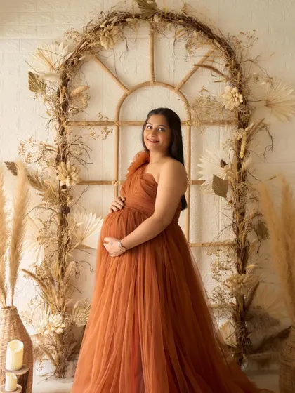 A full-length portrait of our Copper gown in the studio. The warm, earthy tone of the dress pairs perfectly with our boho-themed backdrop.