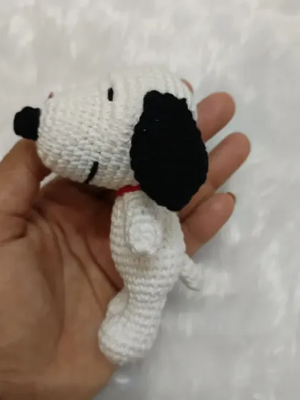 A side view of the little Snoopy charm, showing his tiny red collar and tail. I use 100% cotton yarn, so even my smallest creations are soft and durable.