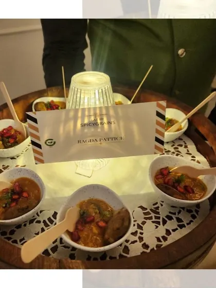 Our Ragda Pattice served in individual portions. The warm pea curry is topped with a crispy potato patty and garnished with pomegranate, a perfect bite-sized snack.