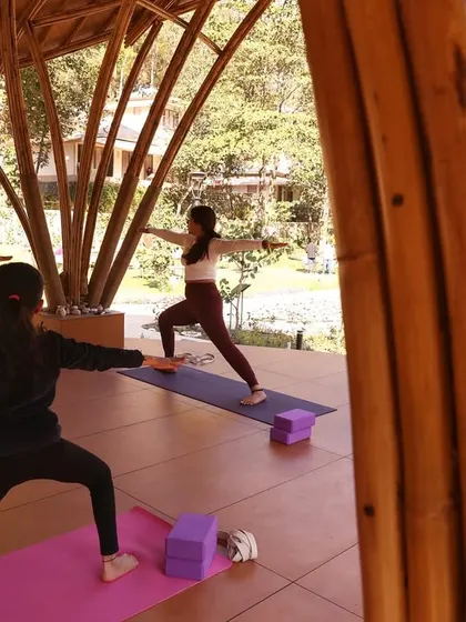 In our asana sessions, we focus on understanding the correct alignments to ensure a healthy flow of prana. Here, students hold Virabhadrasana II in our beautiful bamboo shala, each honoring their own body's journey.