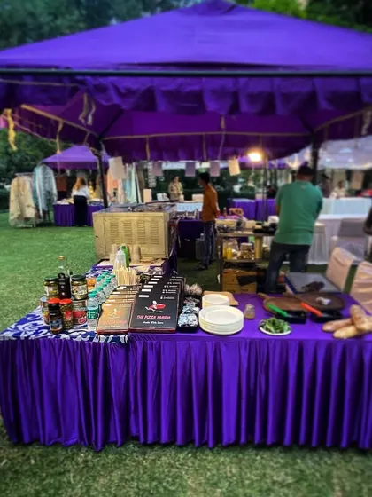 Our fully-stocked food stall at an outdoor exhibition. We provide a complete setup with a menu board, fresh ingredients, and cooking equipment under a professional canopy.