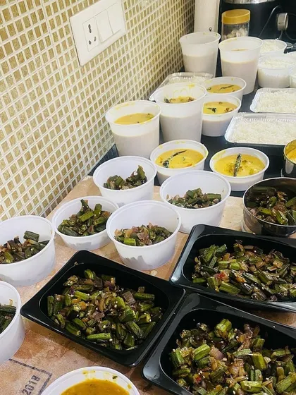 A large order of bhindi, kadhi, and rice being packed for delivery. This is what a typical lunch order looks like, with everything neatly portioned.
