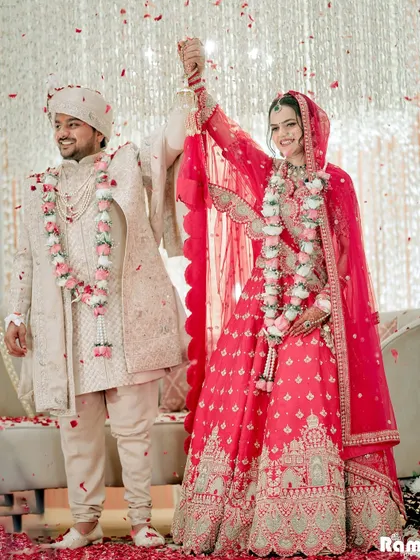 A moment of pure happiness as the couple celebrates their union on stage, showered with flower petals.