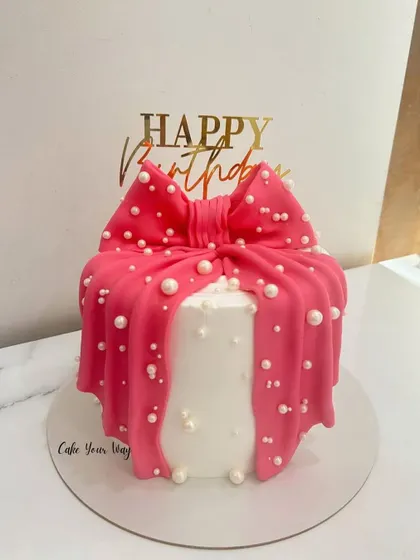 Bow down to the birthday beauty. This cake is designed to look like a gift, with a large pink fondant bow and edible pearls.