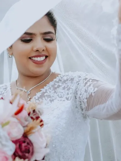 A beautiful close-up of the bride smiling under her veil. The soft light and her happy expression make this a dreamy and romantic bridal portrait.