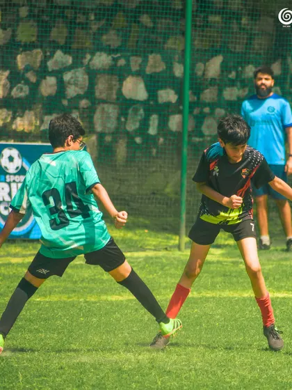 A U-11 player stretches to control the ball.
