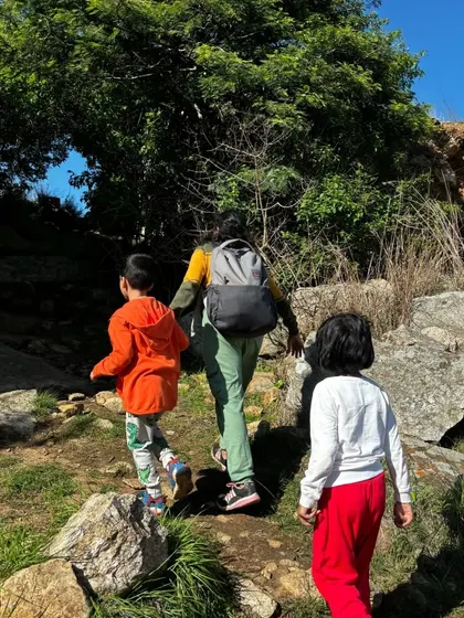 A mother guiding her two young children along a scenic trail.