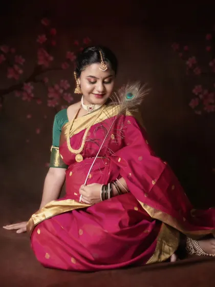 A traditional maternity photoshoot in a beautiful pink and green saree, celebrating cultural fusion and the joy of motherhood.