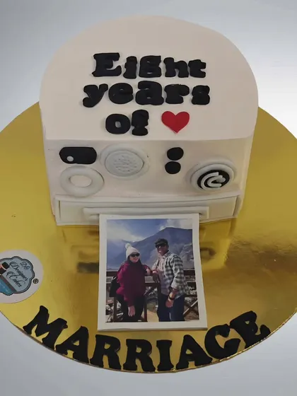 Another version of the Polaroid camera cake, this one celebrating eight years of marriage. It's a fun and nostalgic way to commemorate a special day.