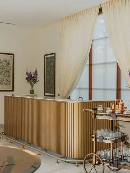 A wider view of the banquet bar area, showing how botanical artwork and fresh flowers soften the space. The design creates a seamless blend of luxury and warmth, suitable for both formal and intimate gatherings.