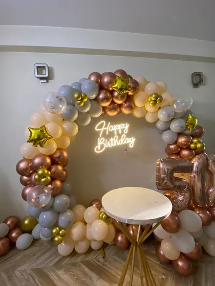 The rose gold, peach, and grey color combination creates a warm and sophisticated look for a 50th birthday celebration.
