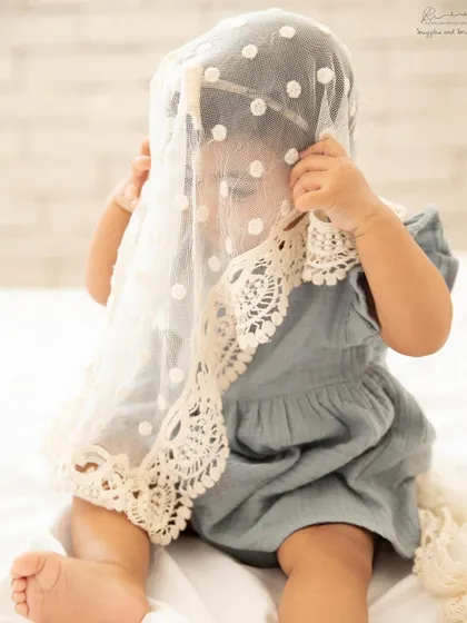 A game of peek-a-boo with a lace blanket. Sitter sessions are full of play and discovery, letting their little personalities shine.