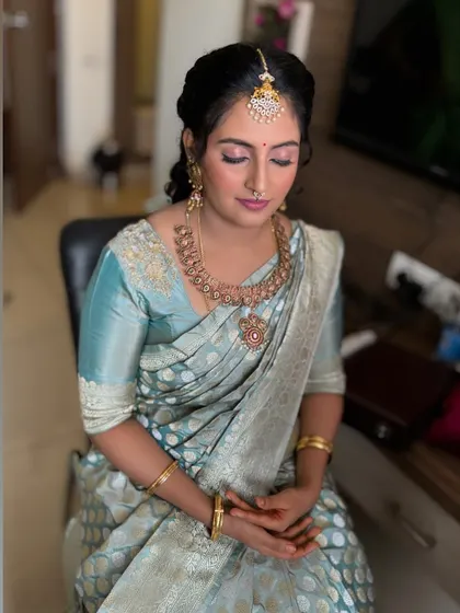 A close-up of Jahnavi's naming ceremony makeup. The skin is fresh and dewy, and the eye makeup is soft and subtle.