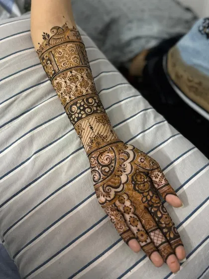 A classic bridal design featuring bands of different patterns along the forearm. This includes floral jaal, leafy vines, and geometric grids for a varied and rich look.
