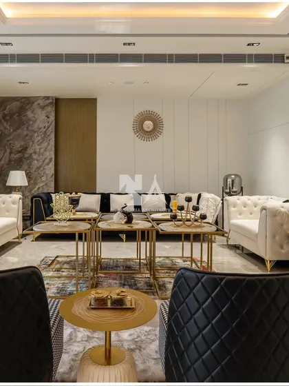 This formal living room is designed for sophisticated entertaining. We paired classic tufted sofas in white with modern quilted black armchairs, creating a chic black-and-white theme with gold accents for a touch of glamour.