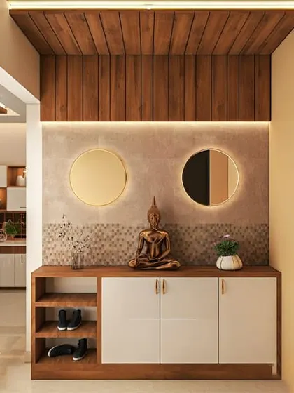 A peaceful foyer featuring a console with a Buddha statue, two round mirrors, and a warm wooden ceiling panel.