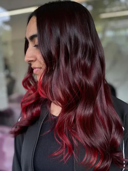 A side profile of the client, her red hair styled into soft, glamorous waves.