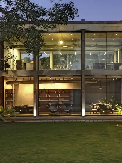 At night, the Automobile Design Studio glows from within, revealing the multi-level interior spaces. The design connects a new glass-and-concrete structure with the existing industrial sheds, creating a dialogue between old and new.