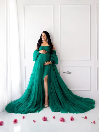 A gorgeous emerald green tiered gown, creating a look of pure sophistication against a clean, white studio background.