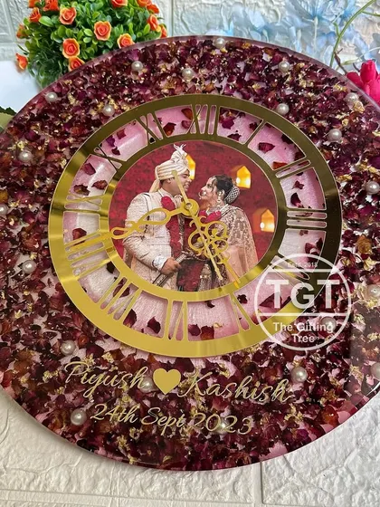 This 16-inch clock was made to celebrate a wedding, preserving the couple's pink and red varmala petals. A photo of the couple is placed in the center of the golden dial.
