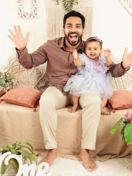 A fun and energetic pose from a father and daughter, showing the playful side of family photos.