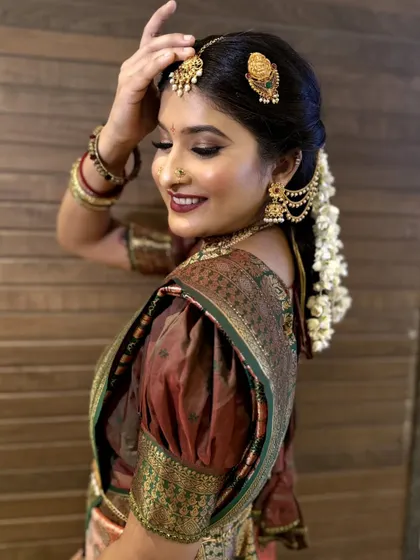 This side profile of the South Indian bride showcases the traditional hairstyle adorned with fresh jasmine flowers ('gajra'), a key component of this classic bridal look.