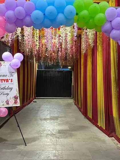 A colorful entrance for a Masha and the Bear themed party, with a rainbow balloon arch and a custom welcome sign.
