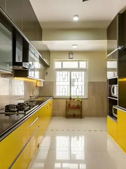 A vibrant parallel kitchen with glossy yellow cabinets and a black countertop, creating a high-energy cooking space.
