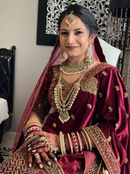 A happy and smiling Geeta on her wedding day. The makeup is designed to be long-lasting and comfortable, allowing her to enjoy every moment.