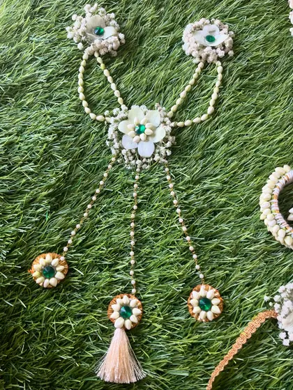 This unique piece is a 'hath-paan' style of haath phool, with floral chains that connect the bracelet to all five finger rings. This was made for a baby shower.
