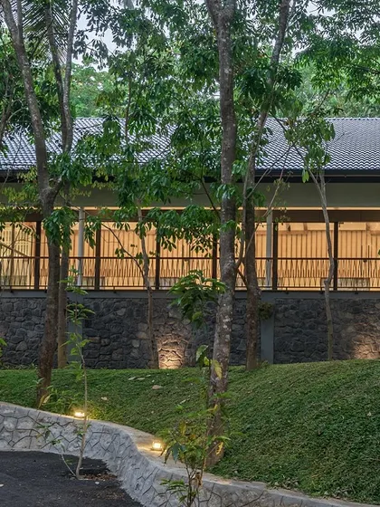 Exterior views of The Leaf Poomala, where the building's stilted metal structure allows it to sit lightly on the terrain, preserving the natural landscape.