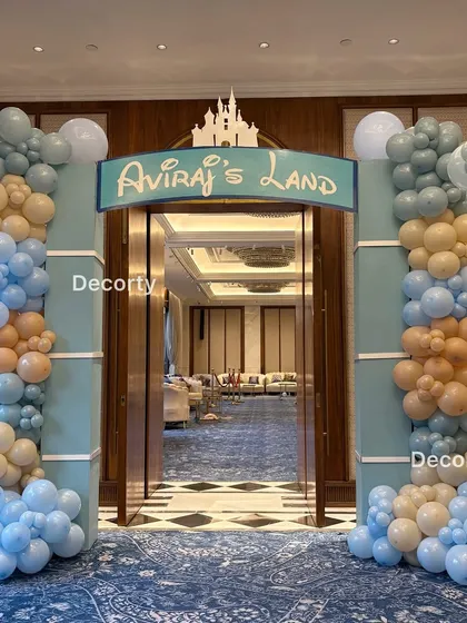 The grand entrance to "Aviraj's Land," framed by columns and beautiful balloon arches in pastel blue and peach, setting a magical tone from the moment guests arrive.