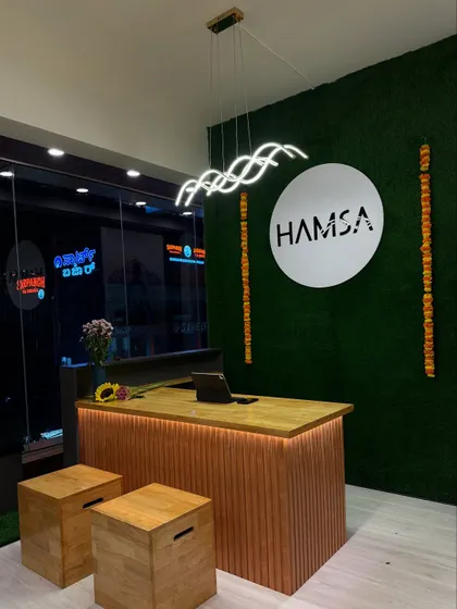 The reception desk at our Akshyanagar studio, where your wellness journey begins. The green moss wall and warm lighting create a natural and calming first impression.