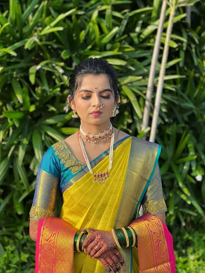 The bride looks radiant in her yellow Nauvari. The simple, clean drape lets her natural beauty and the vibrant color of the saree take center stage.