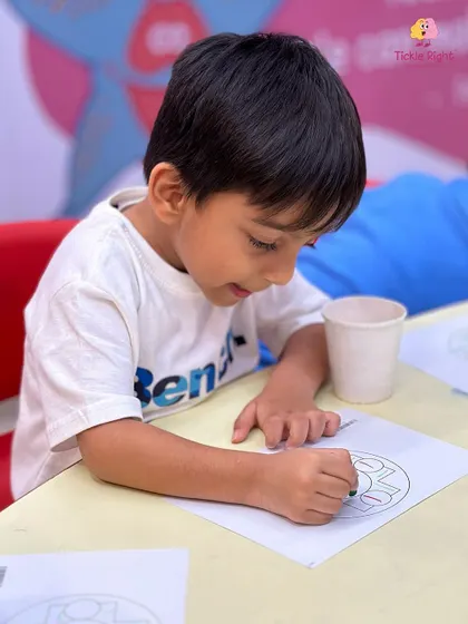 A young boy concentrates on a coloring activity, a simple yet effective way to improve focus and fine motor control.