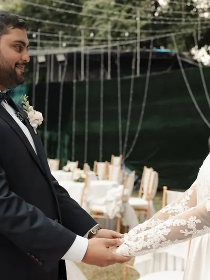 The couple holding hands, taking a moment together before their Catholic wedding ceremony begins.