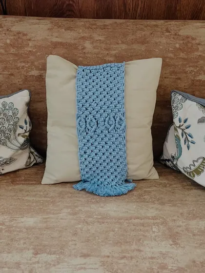 This view shows the blue tie-back on a sofa, nestled between other pillows. The detailed knotting stands out and adds a layer of visual interest to your living room decor.