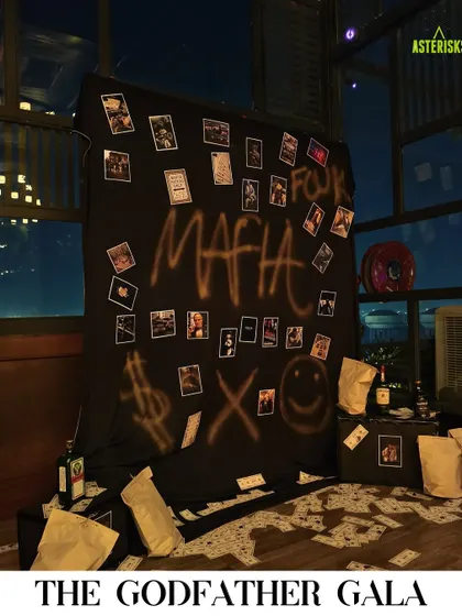 A "Godfather Gala" themed party photo booth. We created a moody, interactive backdrop with graffiti, scattered money, and polaroids for guests to take memorable, in-character photos.