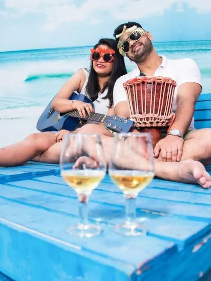 Creating a relaxed vibe with props like a guitar and drinks. This photo from Jyotsna and Rupesh's shoot has a casual, vacation-like feel.