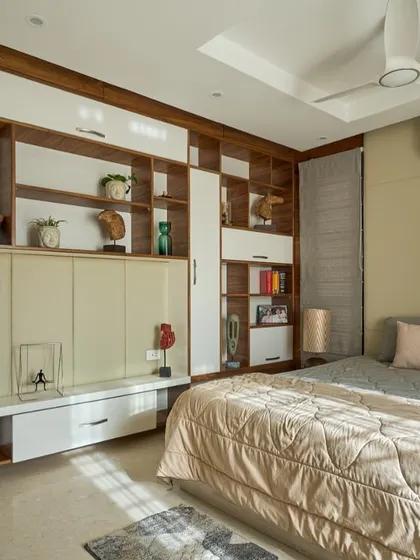 Smart storage is key to a minimalist aesthetic. In this 'Wilasa' bedroom, I designed a wall-mounted unit that combines closed cabinets with open shelves for books and decor, keeping the space uncluttered.