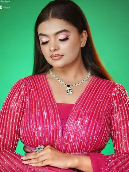 The soft pink eyeshadow complements the outfit perfectly.