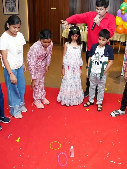 Explaining the rules of a ring toss game. Simple, classic games are often the most fun.