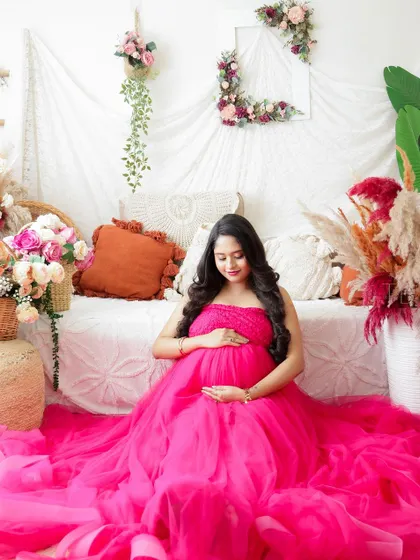 A beautiful portrait of a mom-to-be in a sea of pink tulle. The vibrant color and soft fabric create a stunning and memorable image.