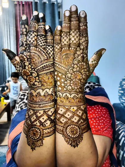 This design showcases beautiful symmetry and classic Indian mehndi motifs, with detailed work on the fingers.