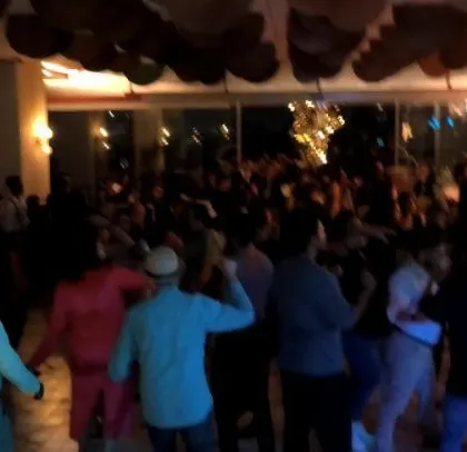 The crowd enjoying the music under the warm lights. I create a vibe that's both fun and sophisticated for corporate events.