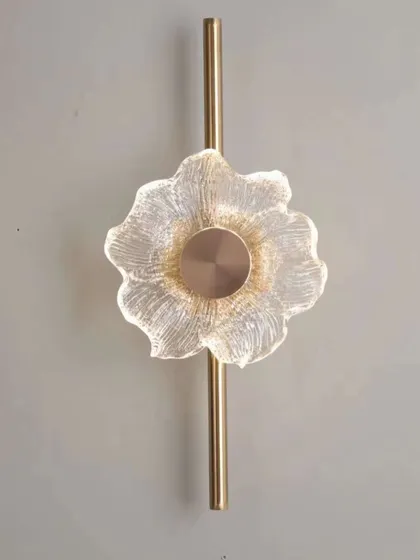 A flower-shaped wall light with a textured glass design on a brass stem. This piece adds a delicate and artistic touch to any wall.