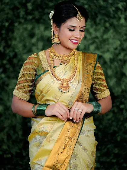 The art of beauty is truly timeless. This bride looks elegant in a yellow Kanjeevaram saree, with makeup that enhances her features and complements her traditional gold jewellery.