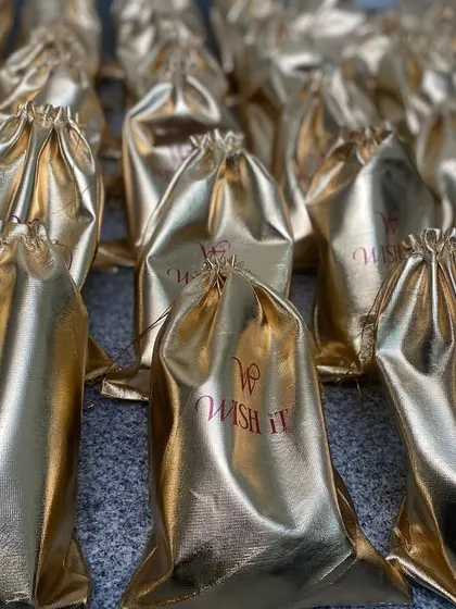 The rich texture and shine of the golden potli bags. They feel like prosperity in your hands, perfect for a milestone event.